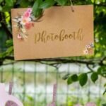 Panneau Photobooth kraft fleuri suspendu à une branche – ambiance champêtre
